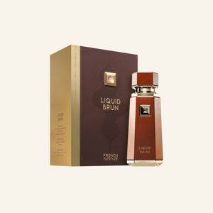A bottle of Liquid Brun perfume by French Avenue stands next to its matching box packaging on a solid cream background. The bottle and box are a warm reddish-brown color with gold lettering and a gold geometric logo accent.