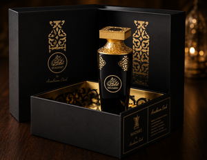Decorative bottle with gold accents in a black box, featuring Arabic script, on a dark background.